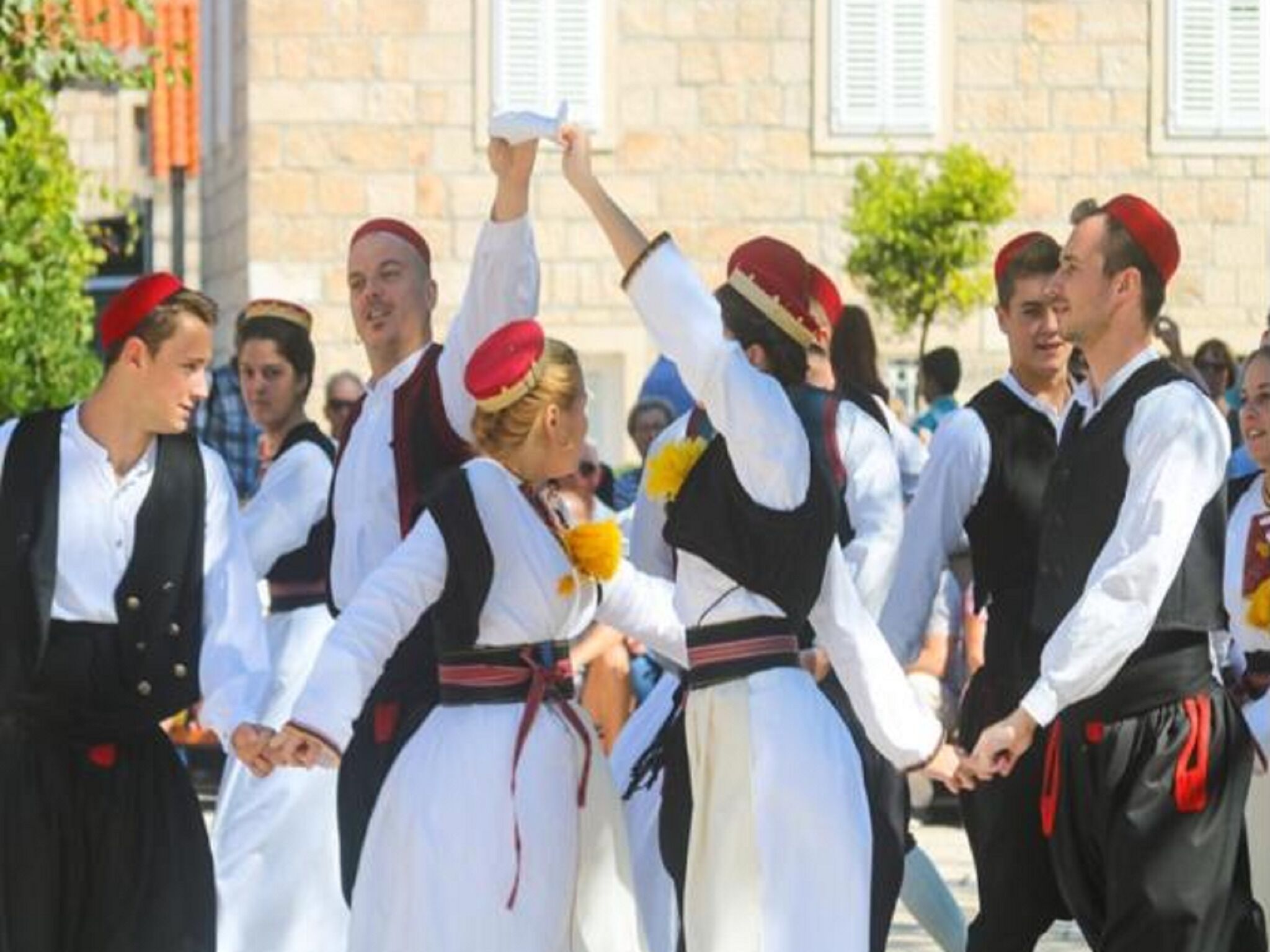 Un groupe de personnes vêtues de costumes traditionnels, participant peut-être à un événement culturel ou à un festival.