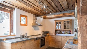 Une cuisine avec des meubles de rangement en bois, un four encastré et un four à micro-ondes.