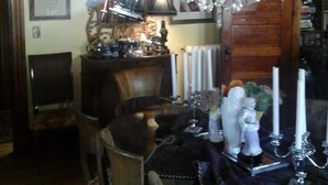 A dining room with a chandelier, wooden furniture, and a mirror. - The Coach House (St. Stephen)