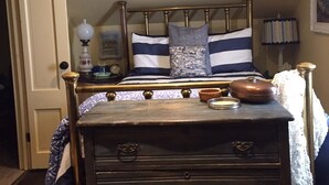 A bedroom with a bed, a dresser, a lamp, and a nightstand. - The Coach House (St. Stephen)