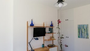 A study area with a desk, computer, shelves, and a potted plant. - Naples from a terrace - 6 (Napoli)