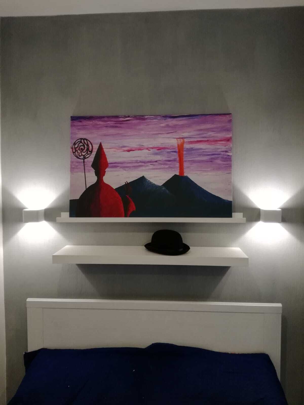 Una pintura de un atardecer con montañas y una figura roja sobre un estante blanco encima de una cama.