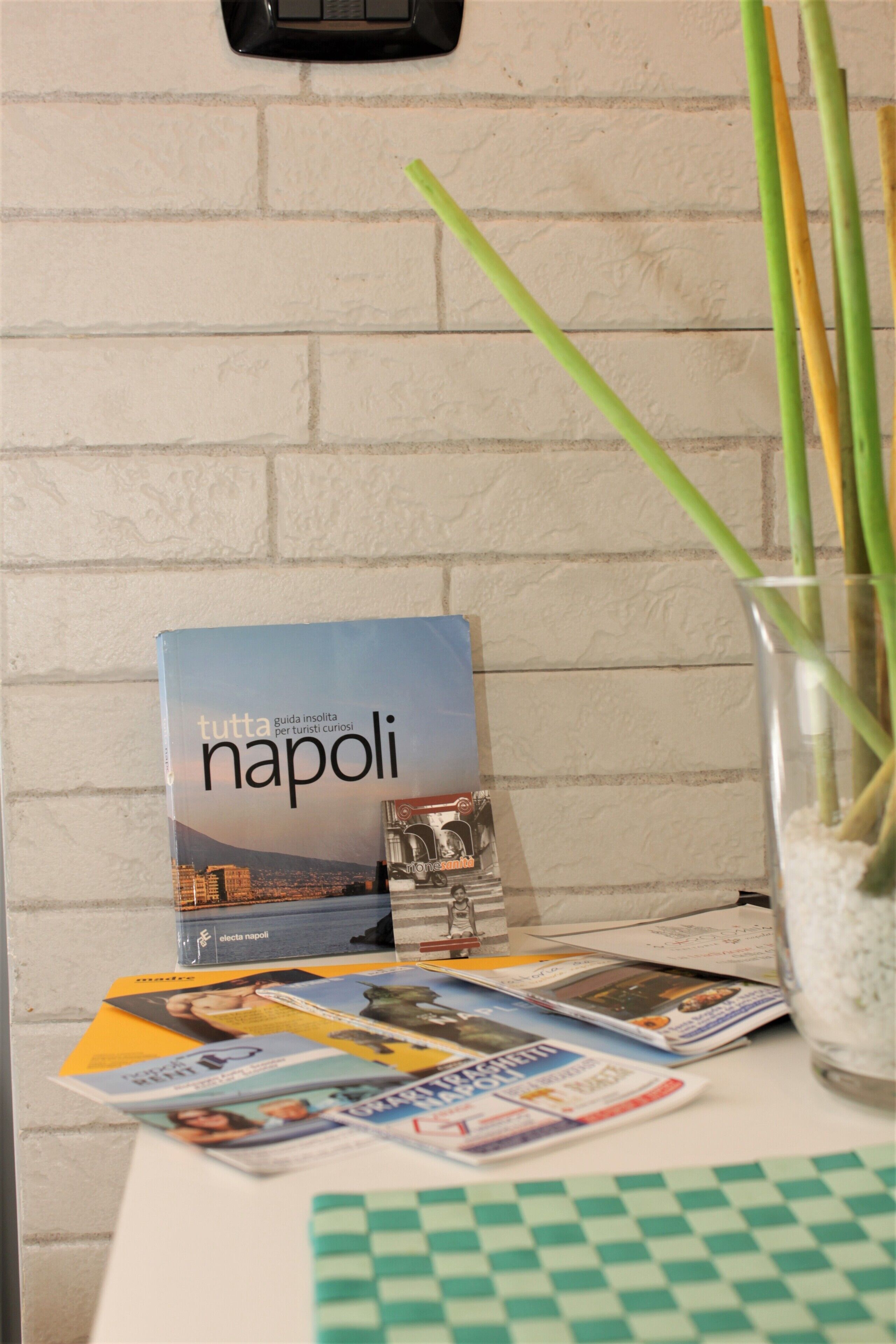 A table with a book titled 'Napoli' and various magazines.