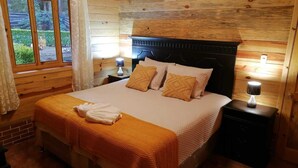A wooden-paneled bedroom with a bed, two bedside lamps, and a window with curtains. - Green Resort (San Martín Jilotepeque)
