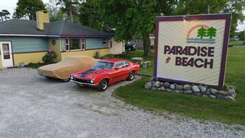 A red car parked in front of a building labeled "Paradise Beach".