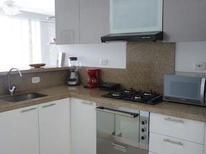 Departamento Deluxe, varias camas, acceso a la alberca, vista al océano | Cocina privada | Refrigerador con congelador, microondas, horno y parrilla de estufa 