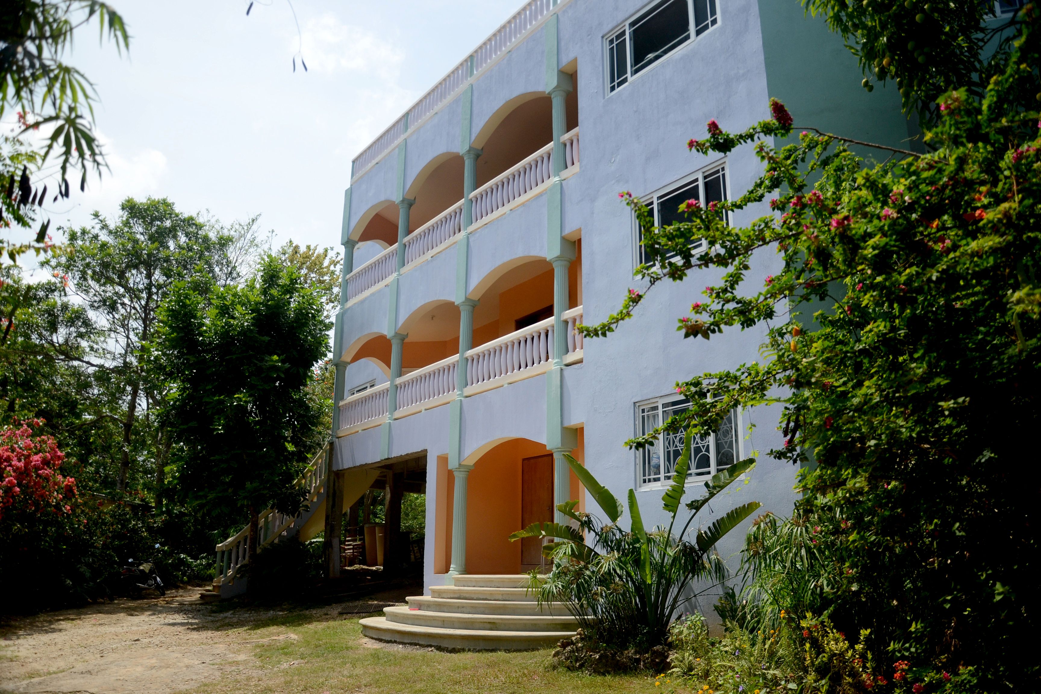 Um edifício com várias andares, varandas e uma entrada central.