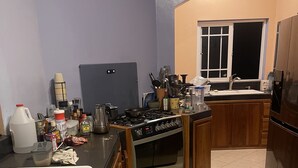 A kitchen with a stove, sink, and cabinets. - Jah Freedom Inn Negril (Negril)