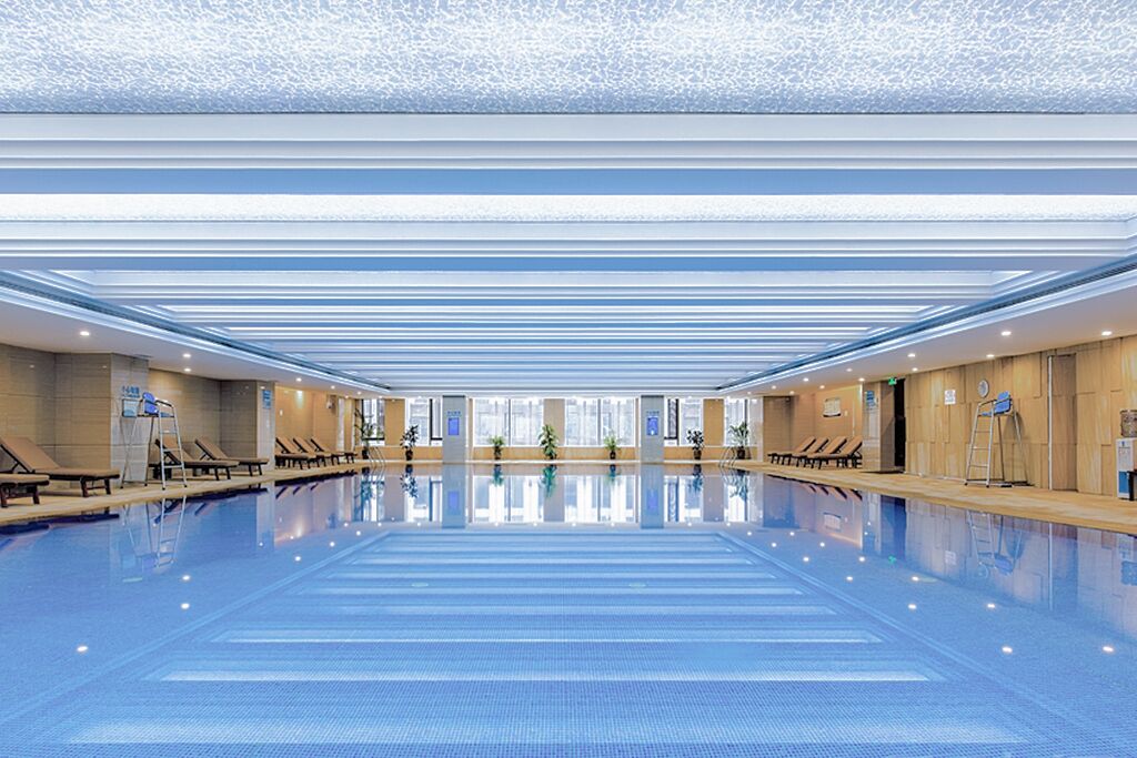 Una piscina techada, sillones reclinables de piscina