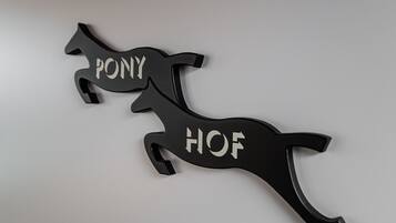 Dos adornos con forma de caballo negro con las palabras "PONY" y "HOF".