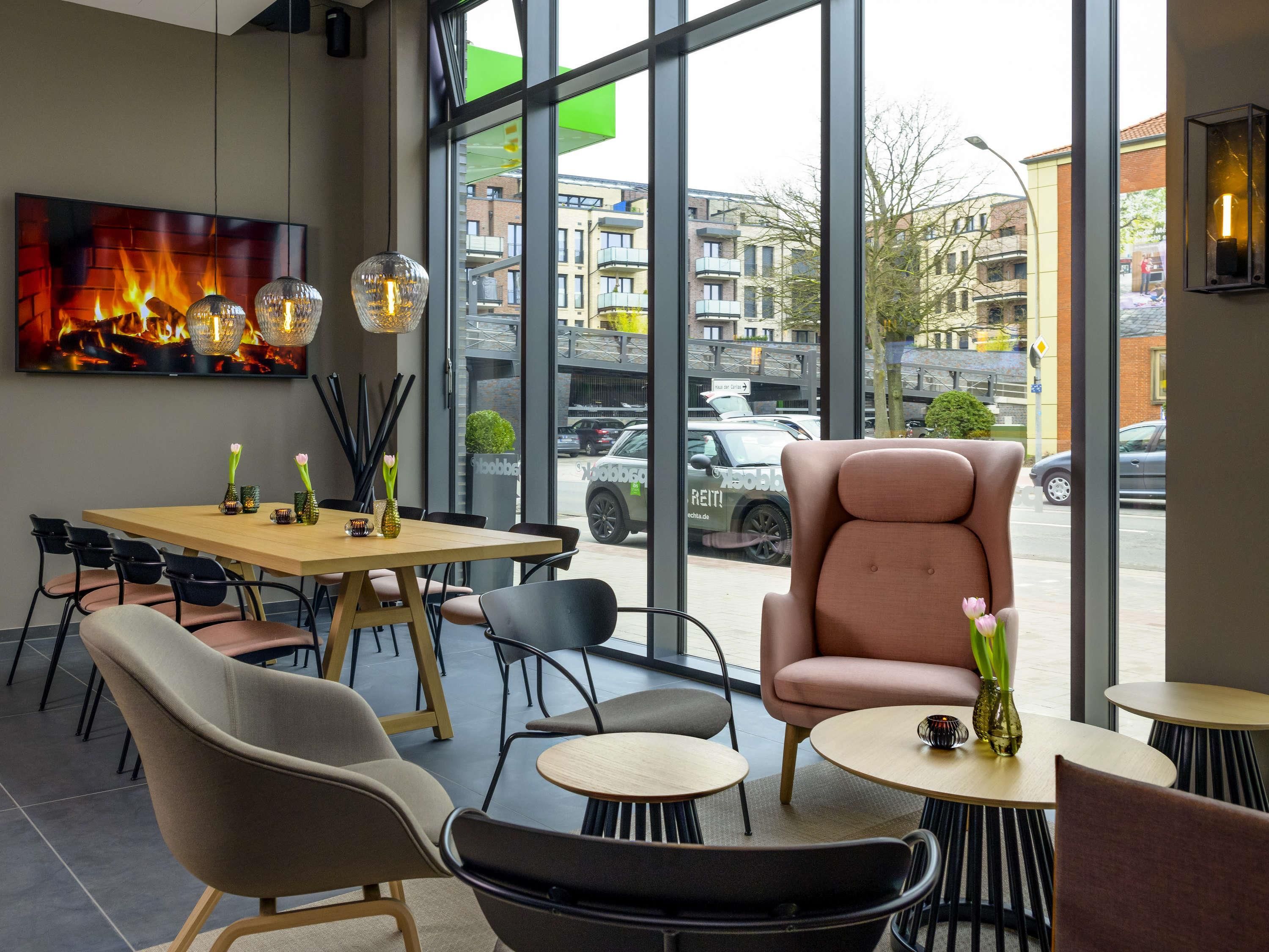 A modern interior with a large window, a wooden table, and several chairs.