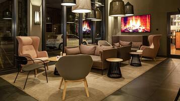 A modern lounge area with sofas, chairs, and pendant lighting.