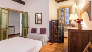 A room with two beds, a wooden cabinet, a mirror, and a radiator. - Piazza Navona Charming Apartment (Rome)