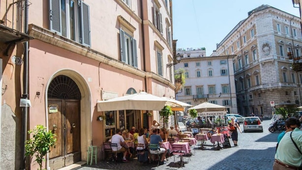 A cobblestone street with outdoor seating at a café, surrounded by historic buildings. - Piazza Navona Charming Apartment (Rome)