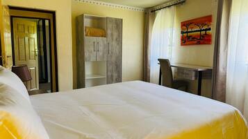 Une chambre d’hôtel avec un grand lit, un bureau et une armoire.