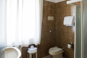 A bathroom with a toilet, a bidet, a towel rack, and a shower curtain. - Albergo Grappolo D'oro (Montebelluna)