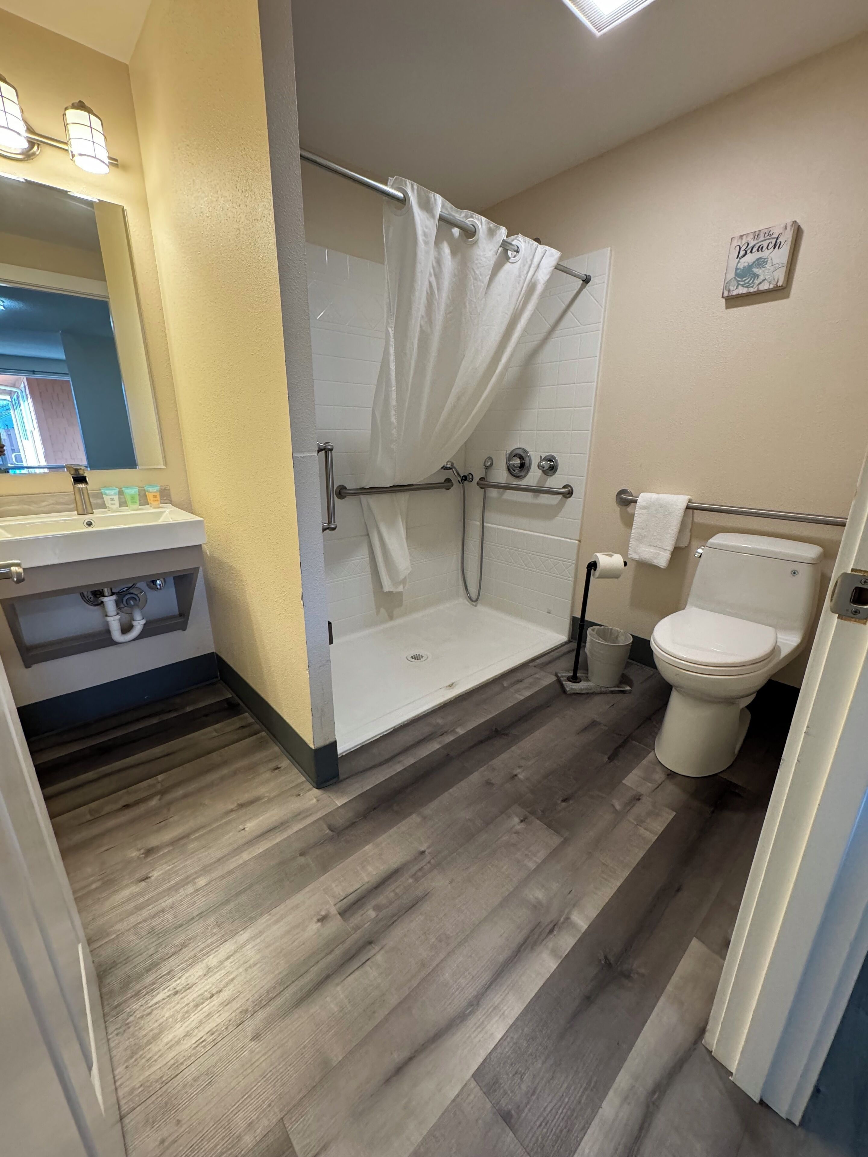 A bathroom with a shower, toilet, and sink.