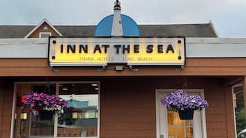 A building with a sign reading "INN AT THE SEA" and "FRANK HOTELS LONG BEACH".