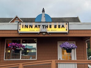 A building with a sign reading "INN AT THE SEA" and "FRANK HOTELS LONG BEACH".