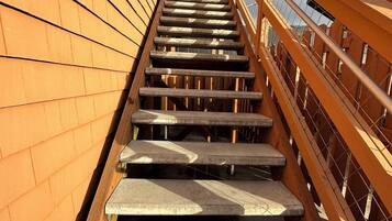 Una escalera de madera con barandillas de metal que sube.