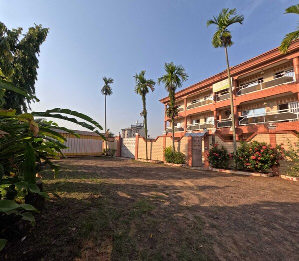 A multi-story building with a brick facade, multiple balconies, and a gated entrance. - Résidence hôtelière Borel Douala (Douala)