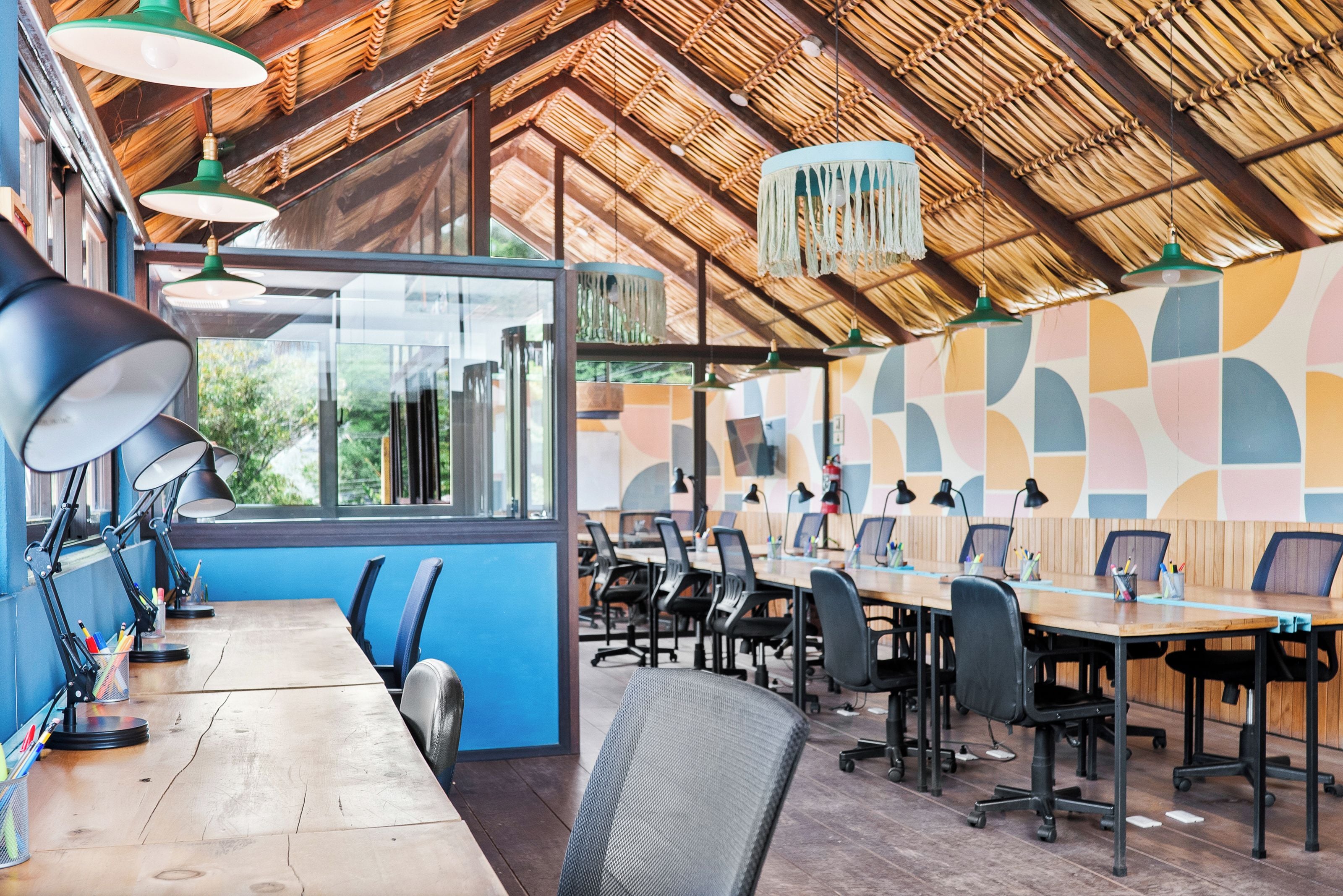 A conference room with a long table, multiple chairs, and pendant lighting.