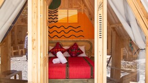 A wooden cabin with a bed, a small table, and a bench. - Socialtel Atitlan (Panajachel)