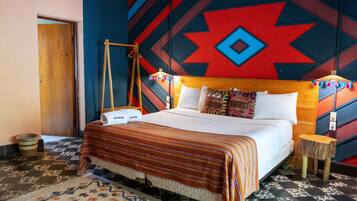A bed with a striped blanket, a wooden headboard, and a patterned rug.