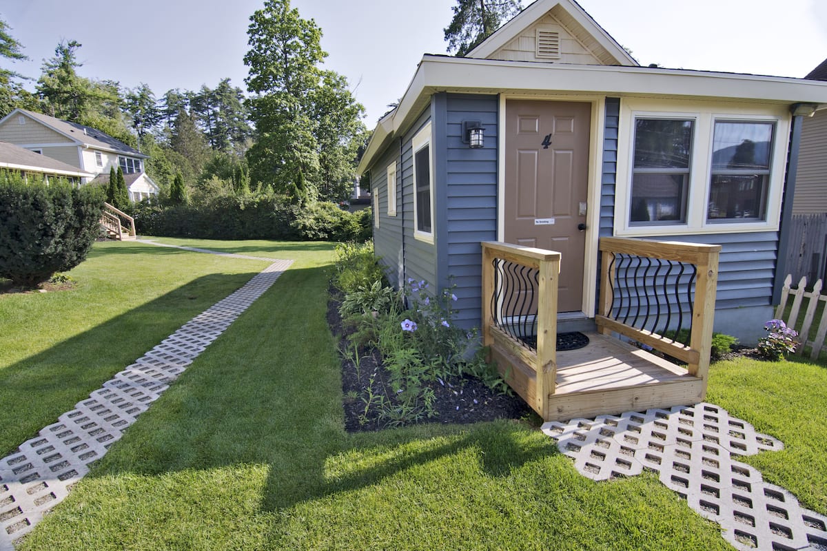 A small house with a wooden deck and a front door.