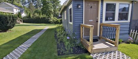 A small house with a wooden deck and a front door.