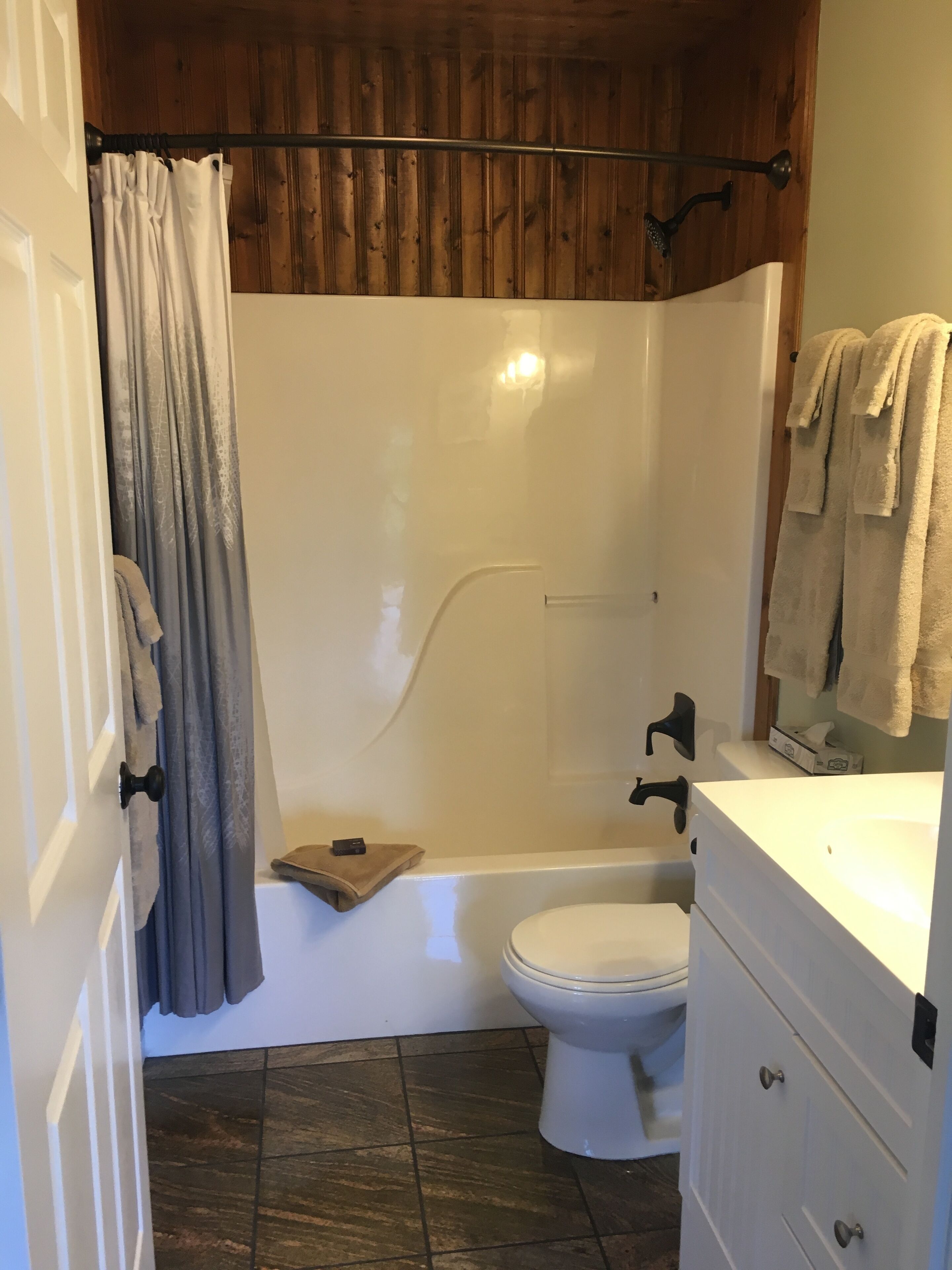 A bathroom with a shower, toilet, and vanity.
