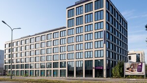 A modern multi-story hotel with a grid of windows, a prominent entrance, and a visible sign for the Premier Inn. - Premier Inn München City Schwabing (Munich)