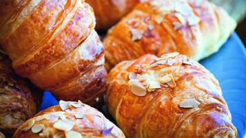 Et nærbillede af flere croissanter på en blå tallerken.
