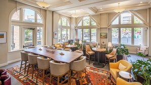 A spacious dining area with a large wooden table, multiple chairs, and a patterned rug. - Hotel E (Santa Rosa)