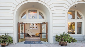 A hotel entrance with a number 37 sign, a wooden door, a staircase, and two potted plants. - Hotel E (Santa Rosa)