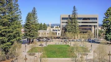 A campus with a central lawn, modern buildings, and a parking area.