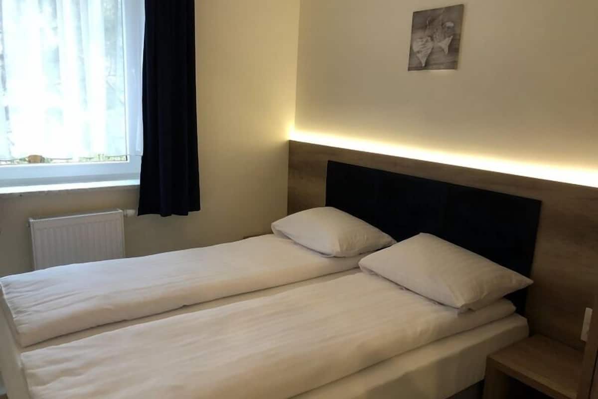 A twin bed with a wooden headboard and a bedside table.