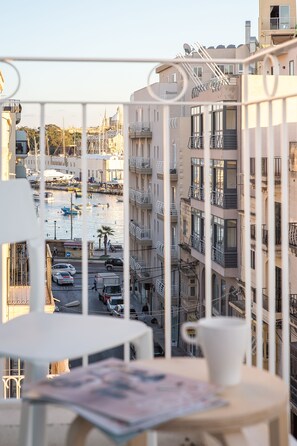 Varanda com vista para uma marina e edifícios.