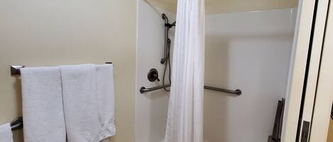 Un baño con ducha, toallero y cortina.
