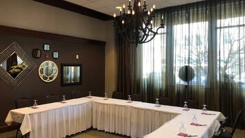 A conference room with a long table, chairs, and a chandelier.