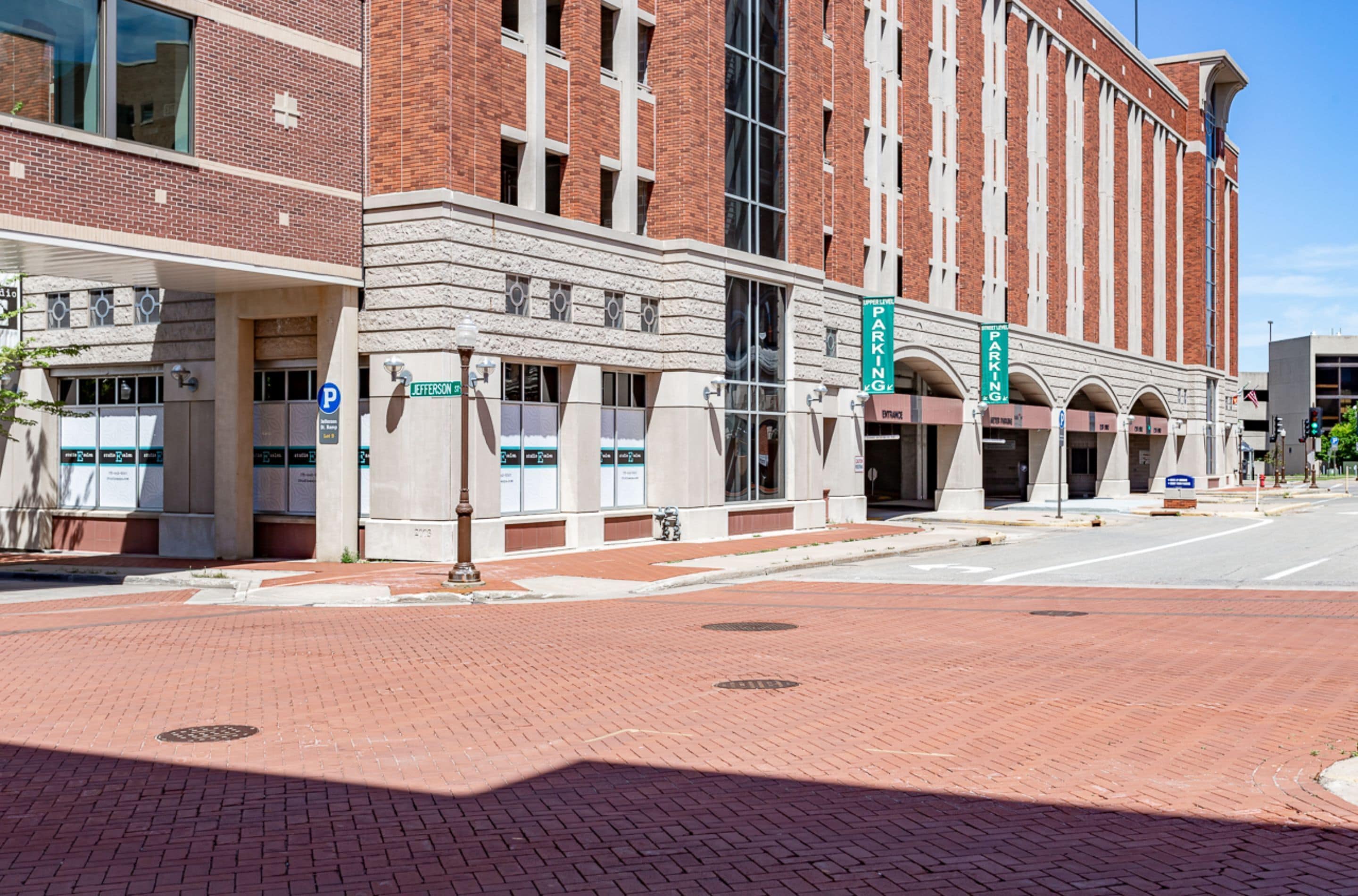 A large brick building with multiple entrances, including a parking garage.