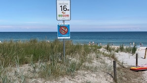A beach with a sign indicating a 16 km distance to the next town.