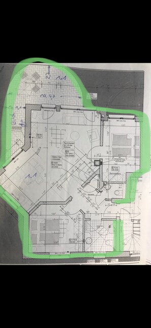 A detailed architectural floor plan of a building with various rooms and spaces marked, including a kitchen, dining area, and multiple rooms with specific dimensions and layout details.