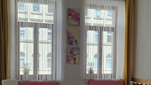 A bedroom with two beds, a chair, and a radiator. - 3-room guest apartment close to the center, suitable for 1 - 4 persons (Leipzig)