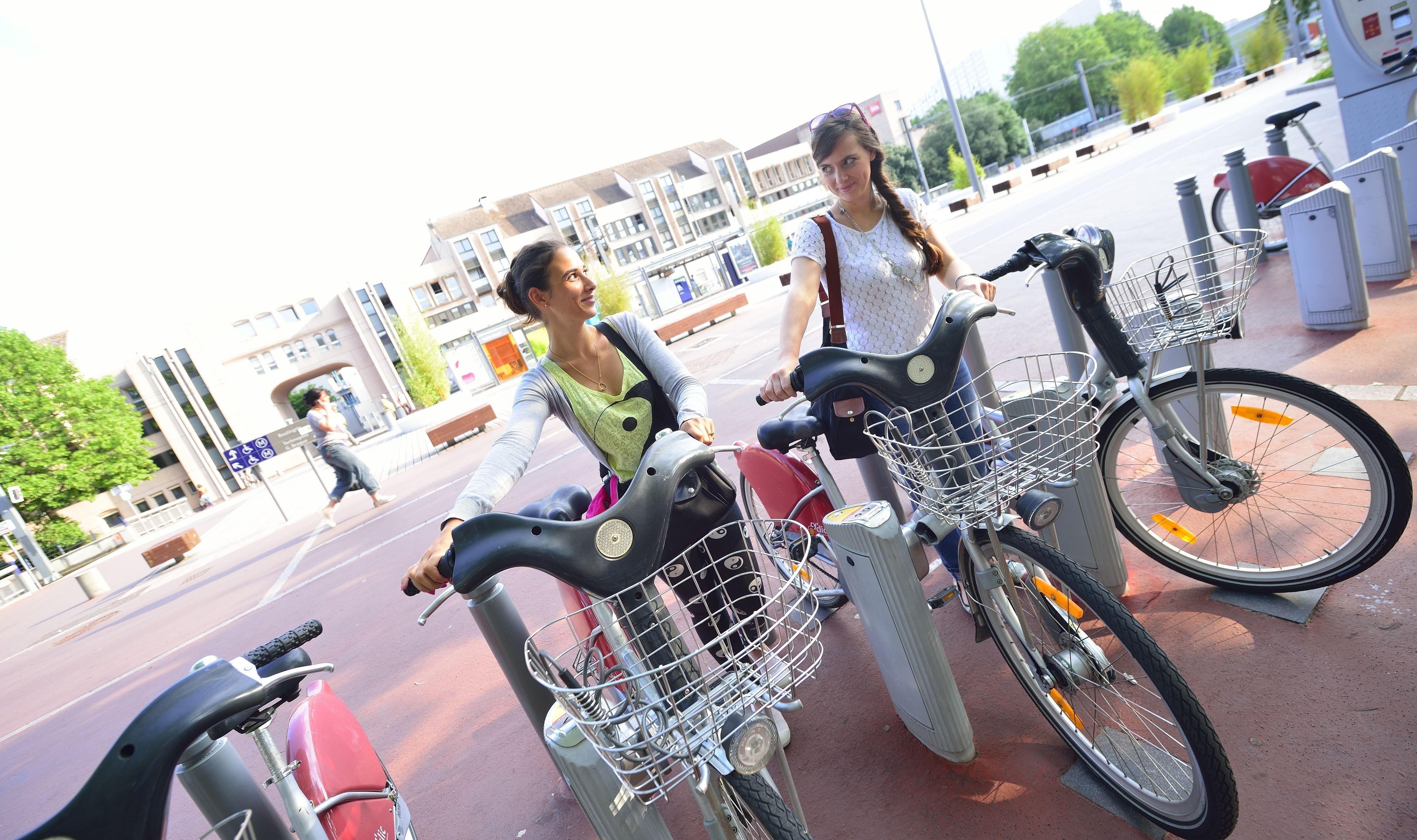 Two bicycles parked on a paved area with a building in the background.
