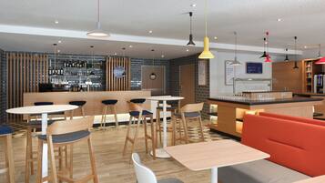 Een moderne bar met een toog, krukken en diverse flessen en glazen.