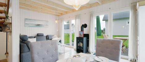 Ein gemütliches Zimmer mit Esstisch für zwei Personen, einer Couch und einem Kamin.