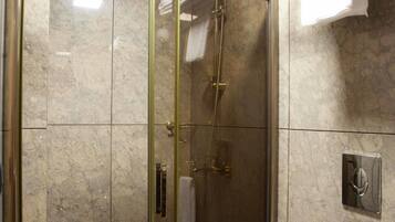 Un baño moderno con ducha de vidrio, inodoro y toallero.