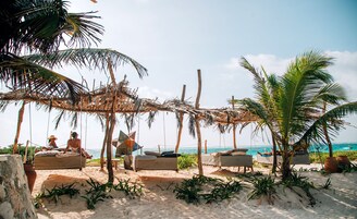 Una playa cerca, arena blanca, sillas reclinables de playa, sombrillas