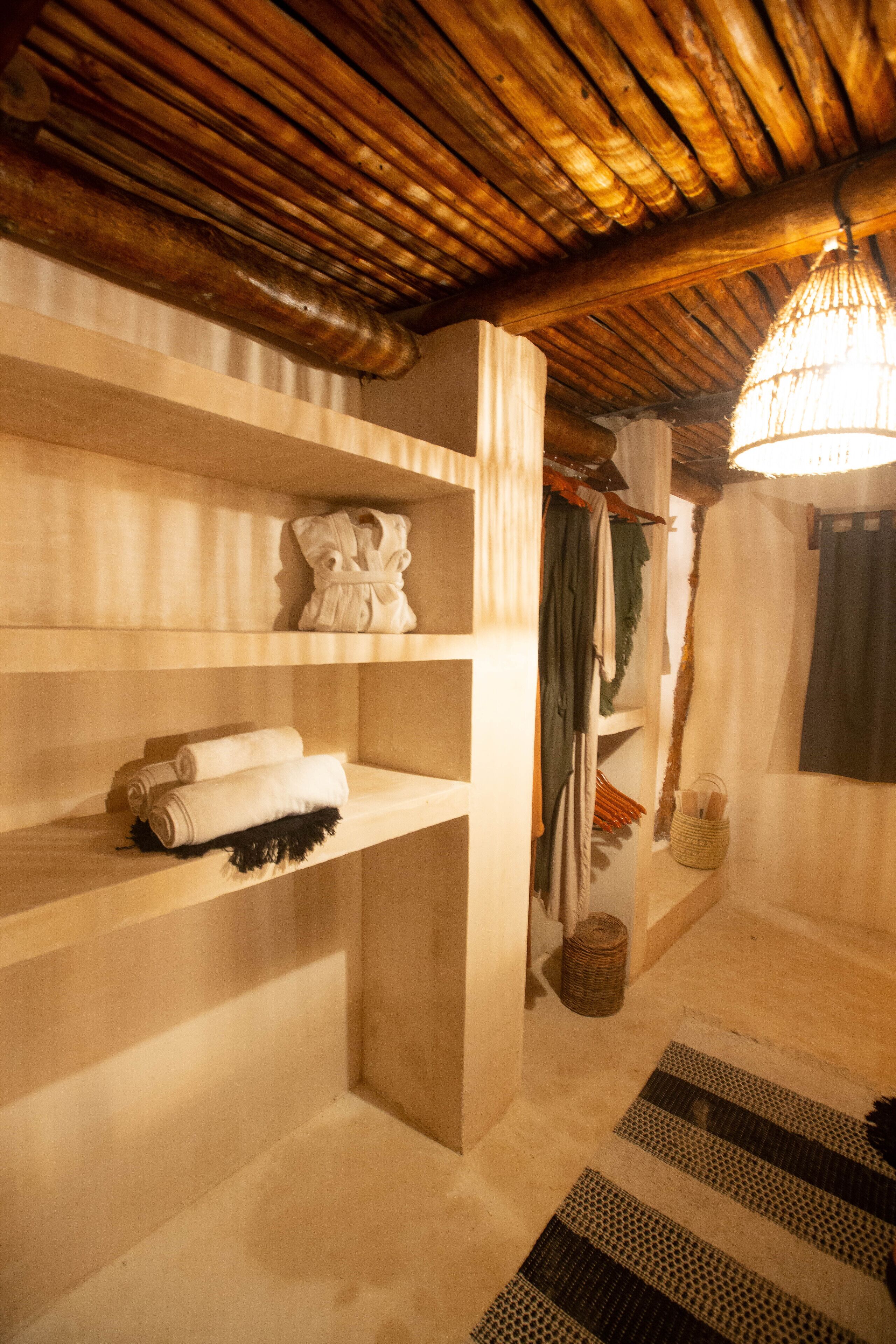 A room with wooden shelves, a hanging light fixture, and a woven basket.